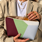 Model opening the color block makeup bag to take out a perfume bottle