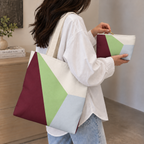 Woman carrying the matching color block tote bag with the makeup bag in her hand