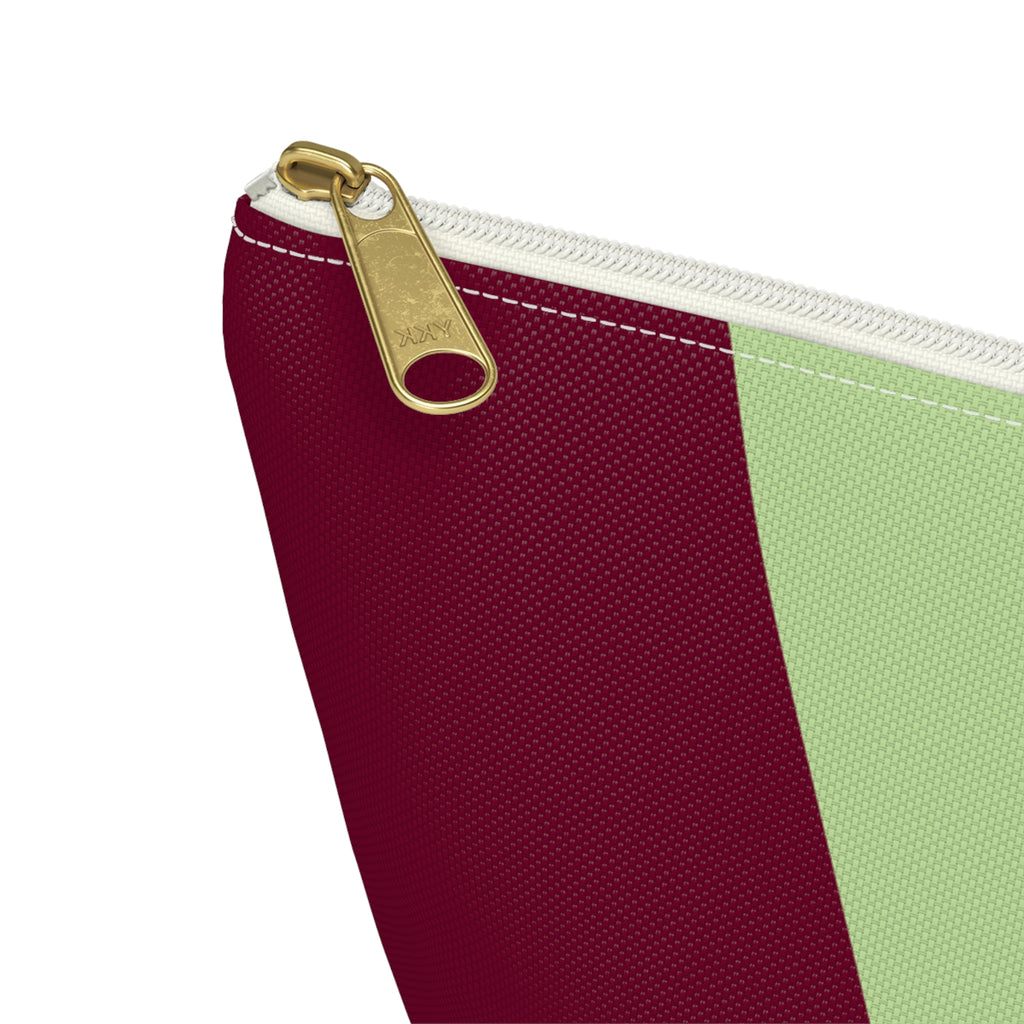 Close-up of the gold zipper pull on the burgundy and green color block makeup bag