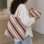Woman with the diagonal striped tote bag and matching makeup bag