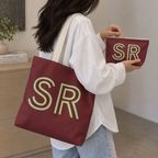 Woman carrying the Burgundy Green Monogram personalized tote bag on her shoulder with the matching makeup bag