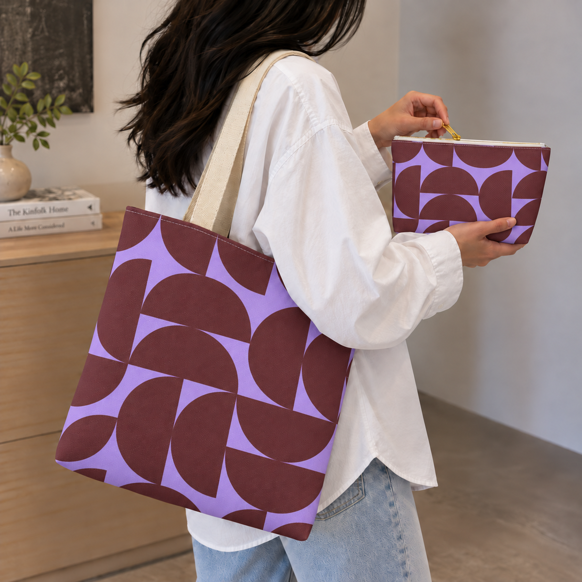 Woman in a white shirt carrying the burgundy lilac half circle tote bag with the matching makeup bag