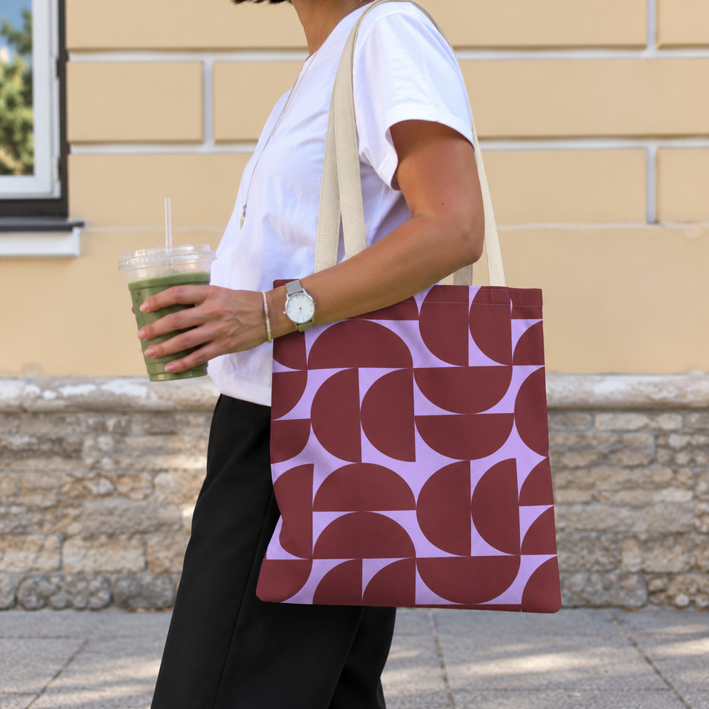 Side view of a model carrying the burgundy lilac half circle tote bag on the shoulder