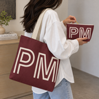 Woman with the burgundy monogram tote bag and matching personalized makeup bag