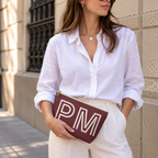 Woman in a white shirt holding the burgundy personalized makeup bag as a clutch