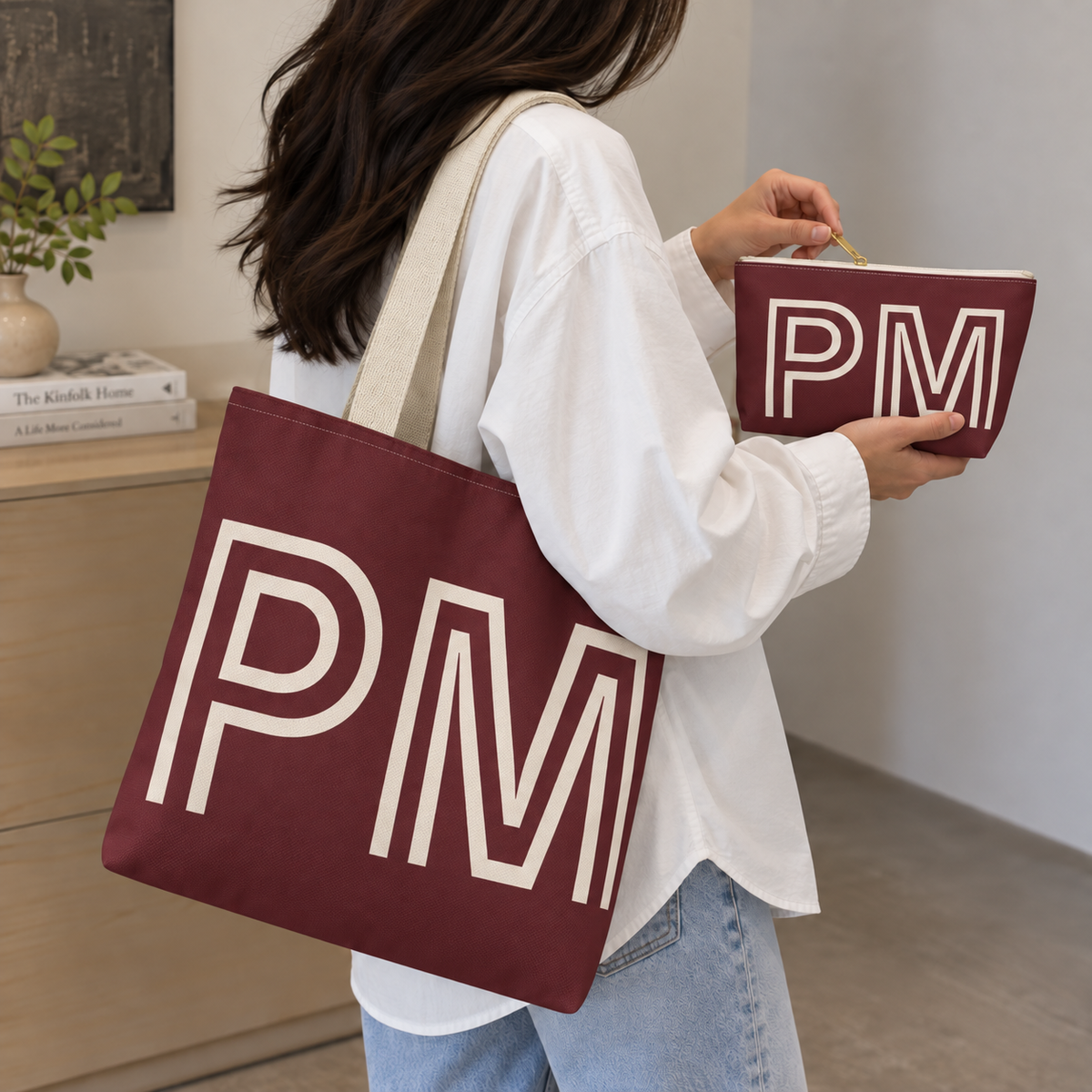 Woman carrying the burgundy monogram tote bag next to the matching personalized makeup bag