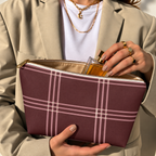 Model in a beige blazer taking a product out of the open burgundy pink plaid makeup bag