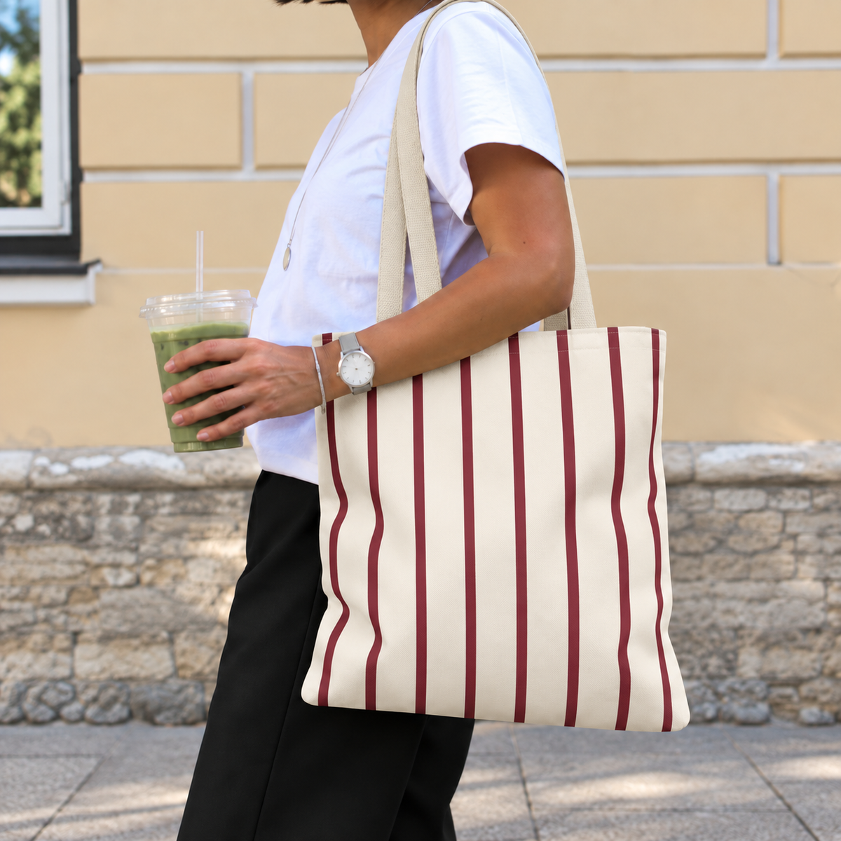 Woman carrying the burgundy pinstripe tote bag on her shoulder on the street
