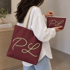 Woman carrying the burgundy monogram tote bag with the matching makeup bag in her hand