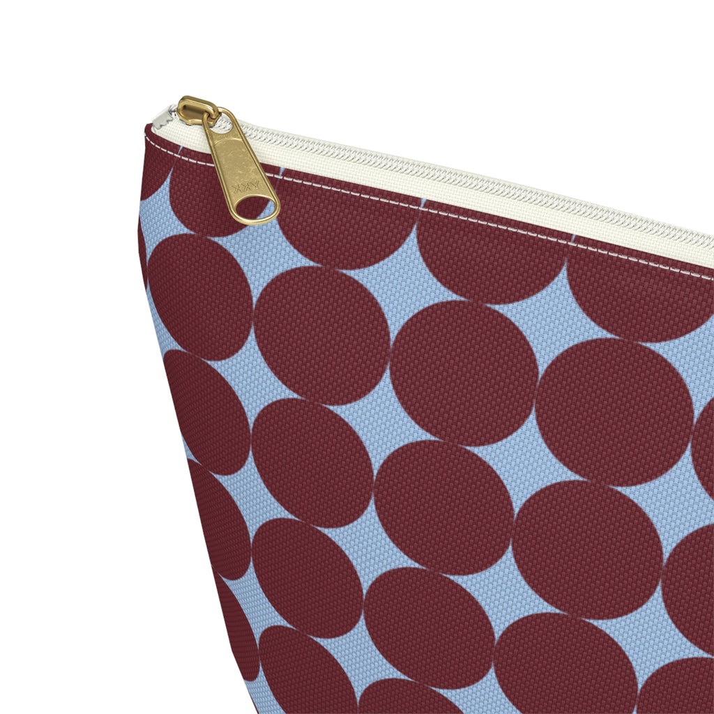 Close-up of the burgundy circle print and gold zipper pull on the makeup bag