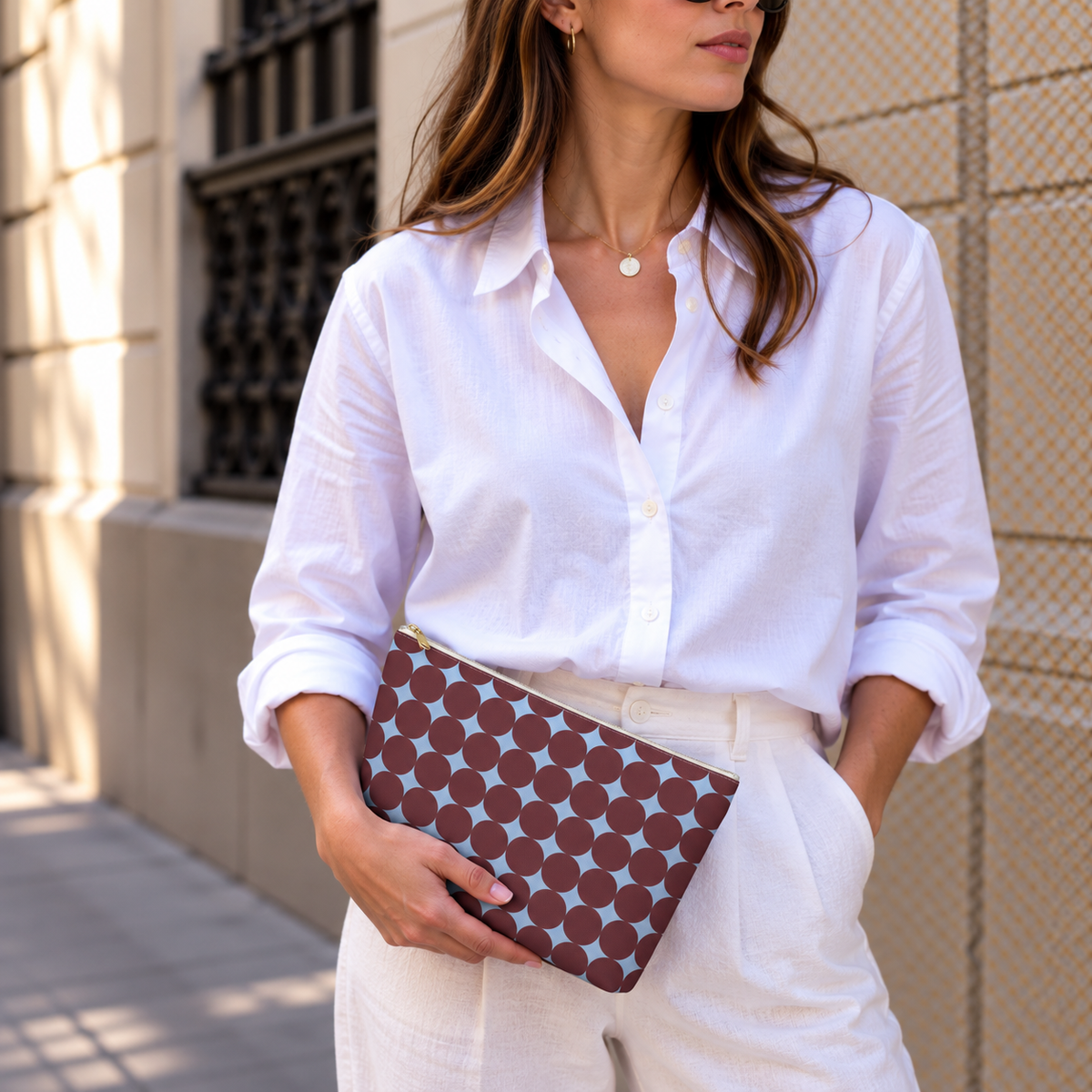 Model holding the Burgundy Sky Blue Geometric makeup bag like a clutch