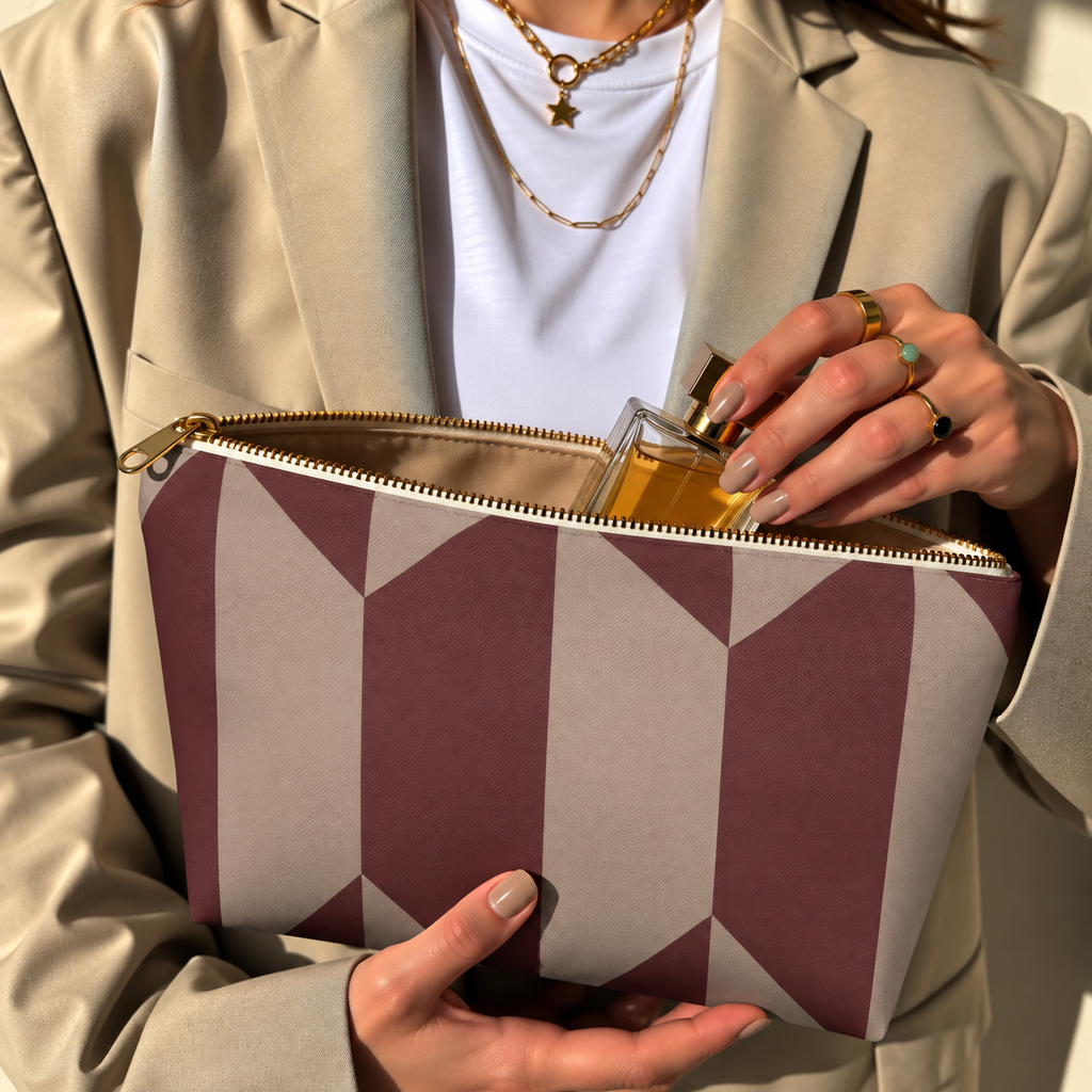 Model in a beige blazer taking a product out of the open burgundy taupe geometric makeup bag