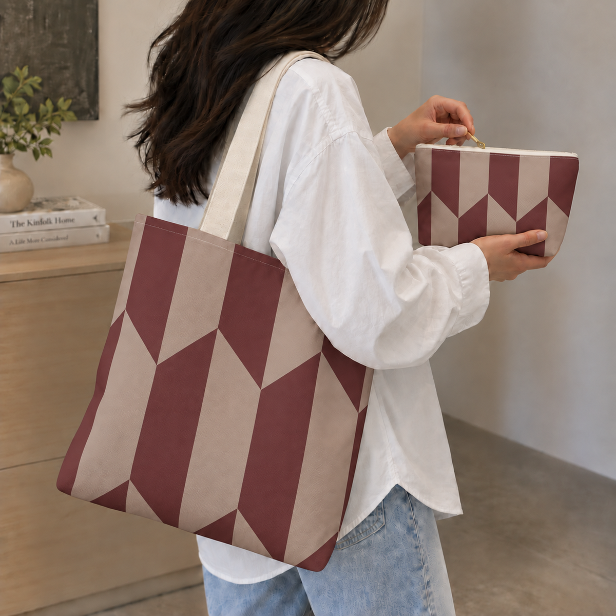 Woman carrying the burgundy taupe geometric tote bag while holding the matching makeup bag
