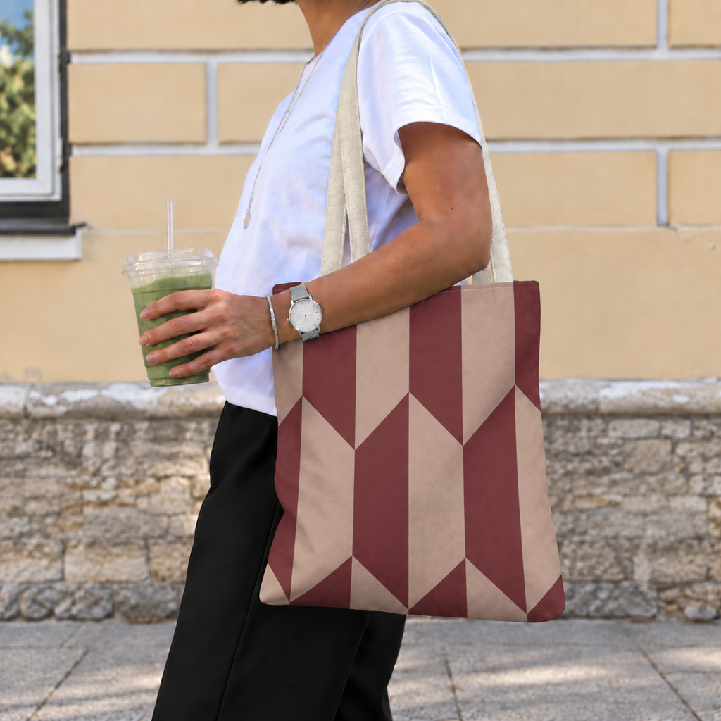Side view of a model carrying the burgundy taupe geometric tote bag on the shoulder