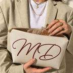 Model opening the cream monogram makeup bag to take out a perfume bottle