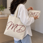 Woman carrying the cream monogram tote bag with the matching makeup bag in her hand