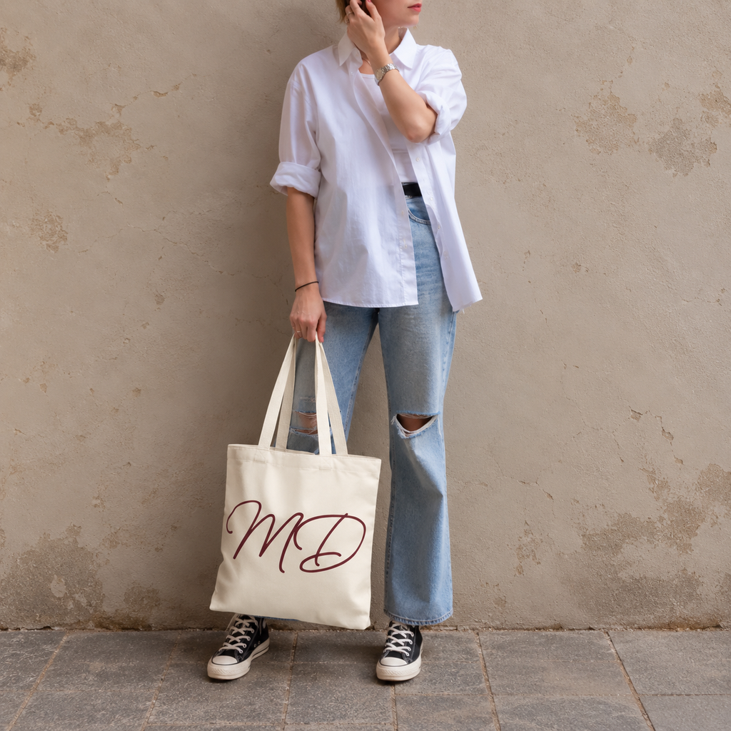 Model in jeans standing with the cream burgundy monogram personalized tote bag