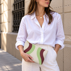 Woman in a white shirt holding the Cream Green Burgundy Wavy makeup bag
