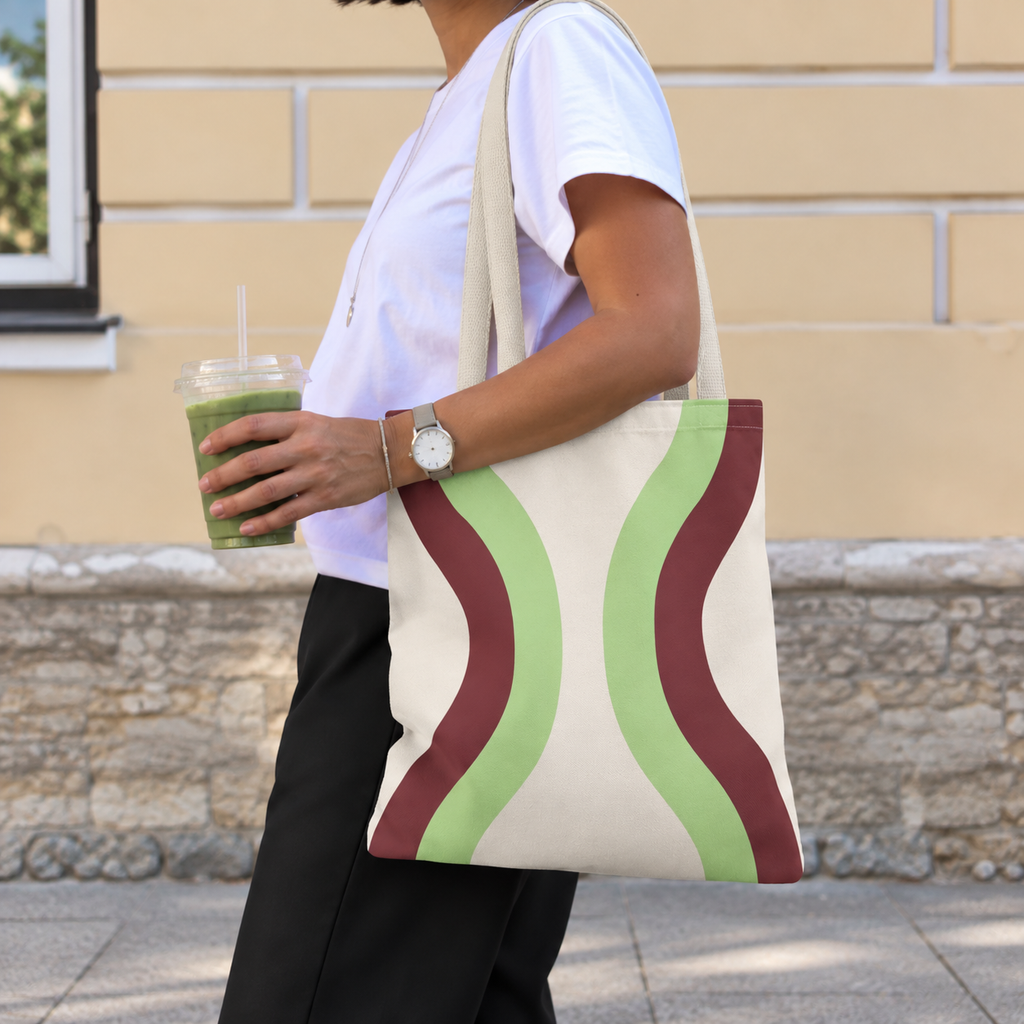 Woman carrying the Cream Green Burgundy Wavy tote bag, side view with an iced drink