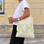 Woman carrying the Cream Green Monogram personalized tote bag, side view with an iced drink