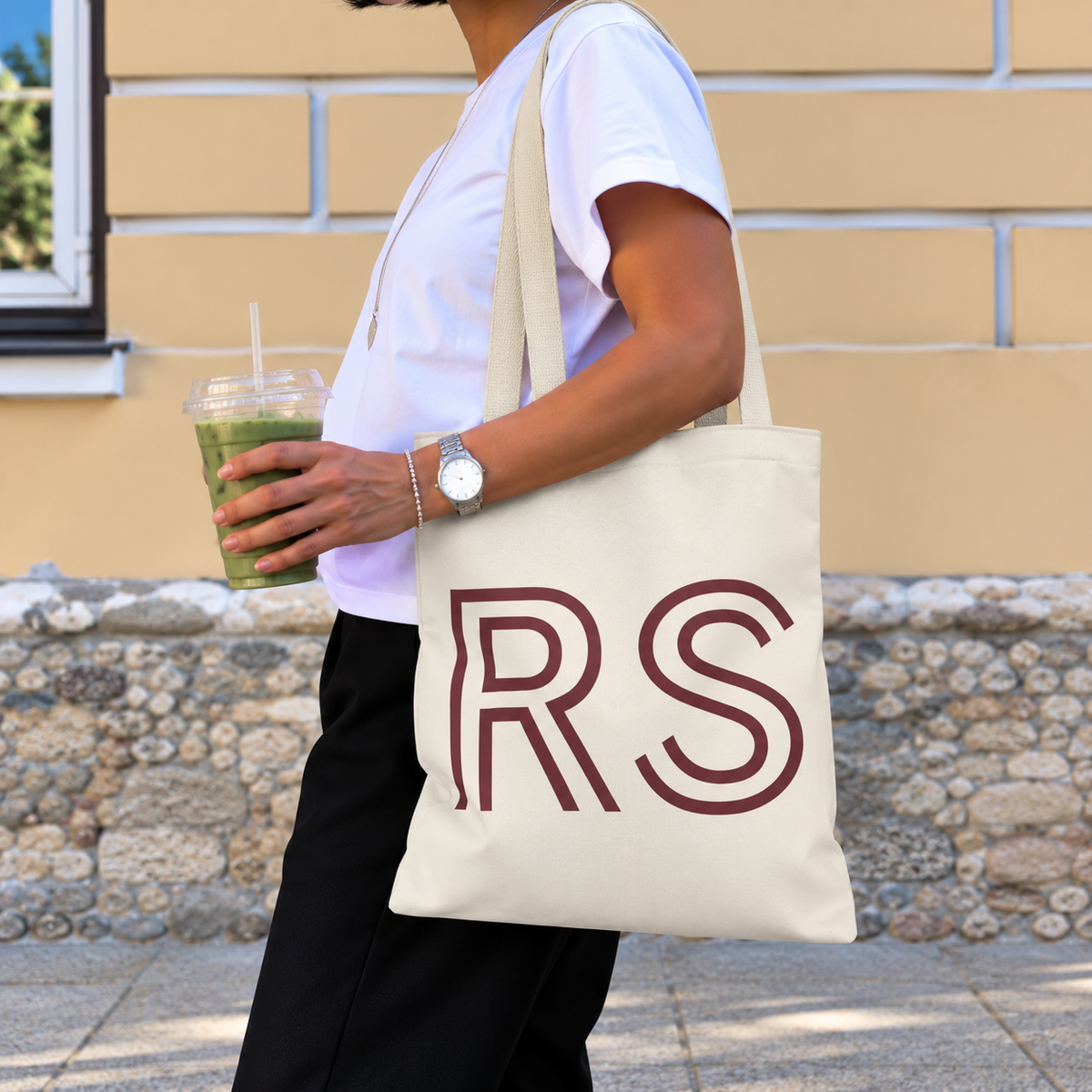 Woman with an iced drink carrying the cream RS monogram personalized tote bag