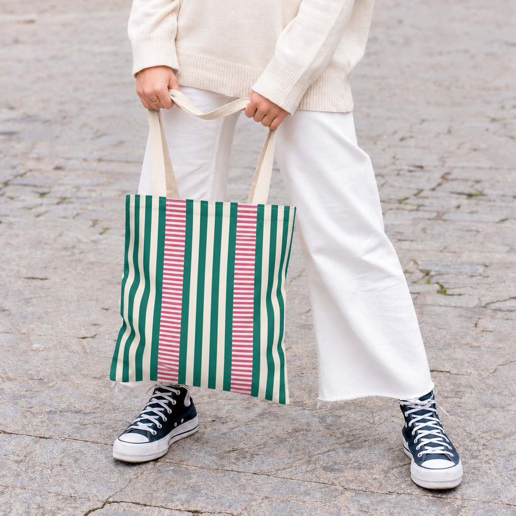 Model in white trousers carrying the Emerald Green Pink Striped tote bag