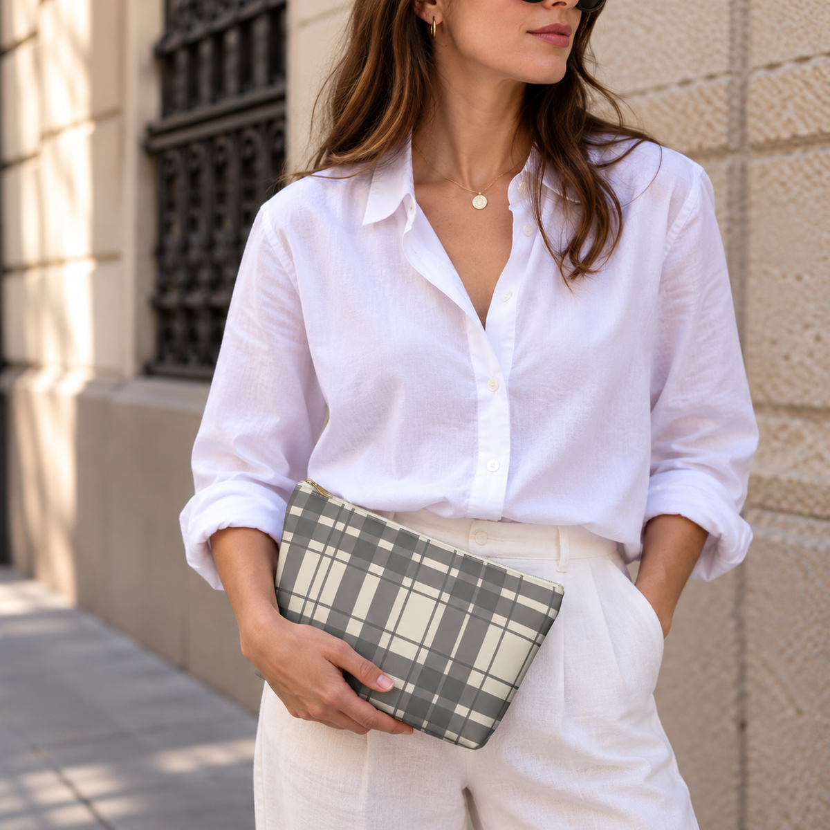 Woman in white shirt holding the gray cream plaid makeup bag