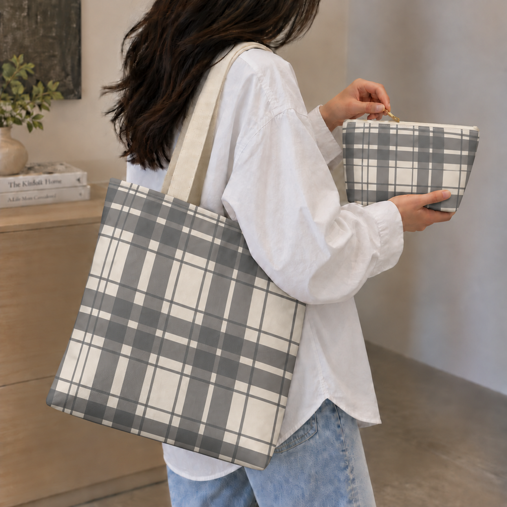 Woman carrying the gray cream plaid tote bag with a matching plaid makeup bag in her hand