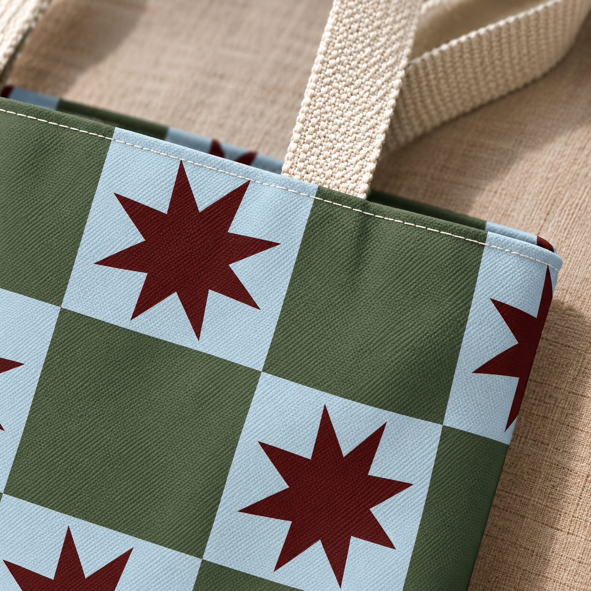 Close-up of a burgundy star on the green and blue checkerboard print and beige handle
