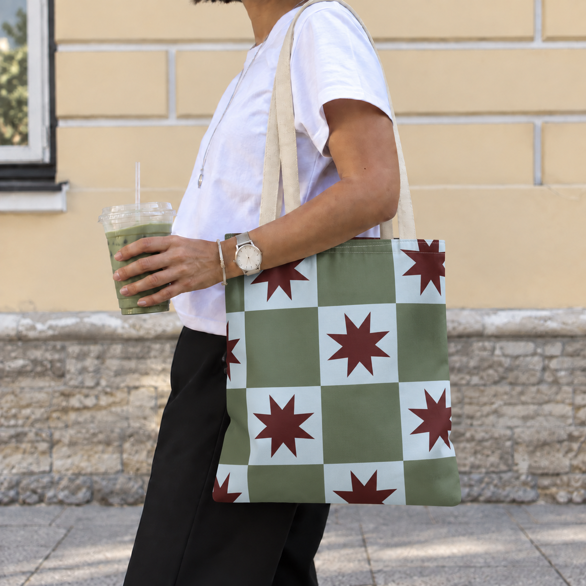 Side view of a model carrying the green blue star checkered tote bag on the shoulder