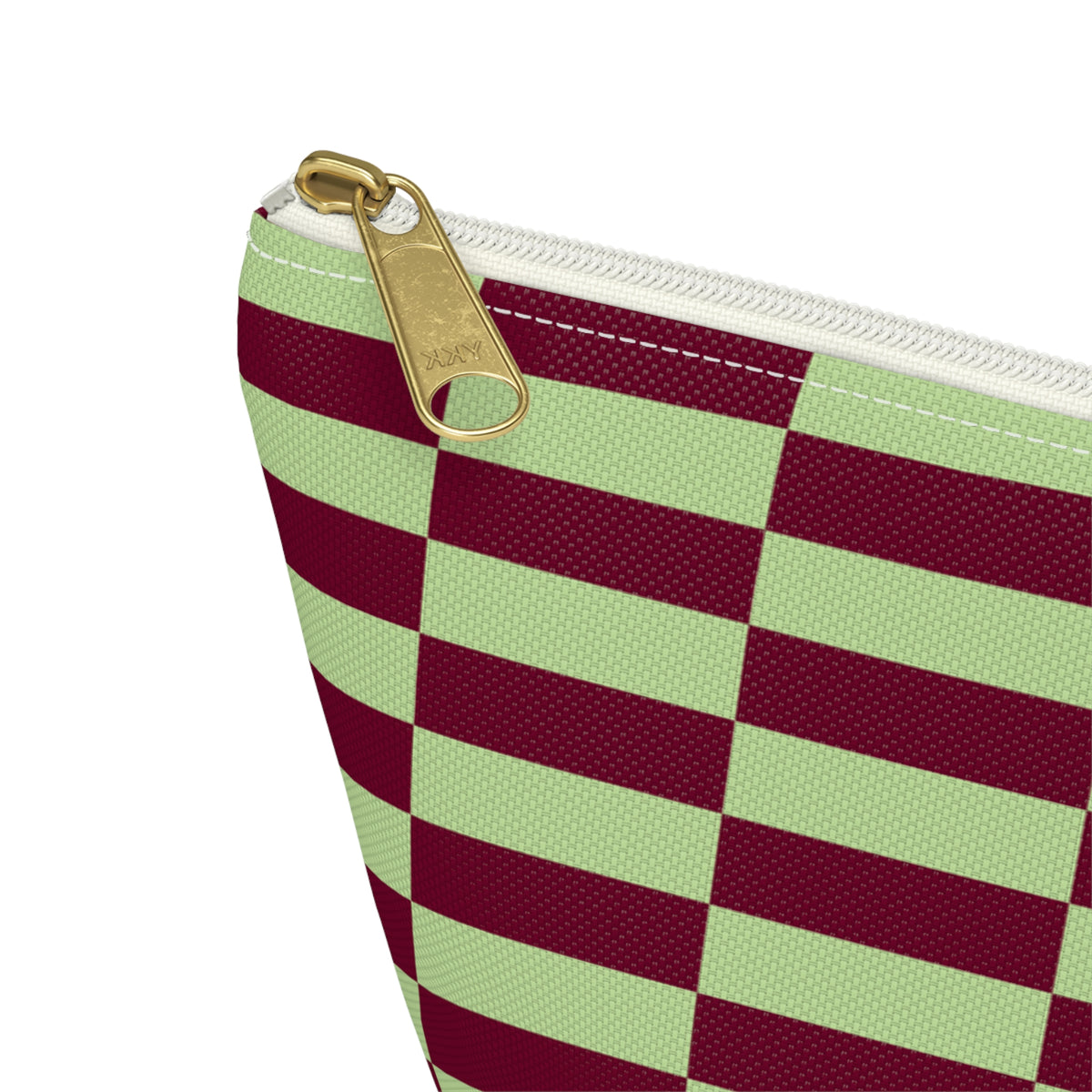 Close-up of the gold zipper pull on the green burgundy checkered makeup bag