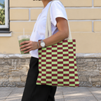 Woman carrying the green burgundy checkered tote bag on her shoulder while holding a drink