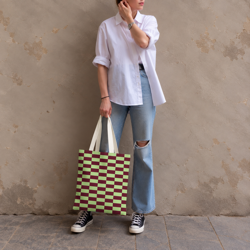 Woman standing in jeans and a white shirt with the green burgundy checkered tote bag