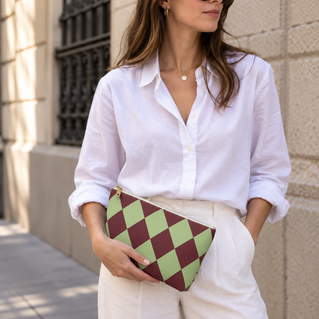 Woman in white shirt holding the green burgundy checkered makeup bag as a clutch
