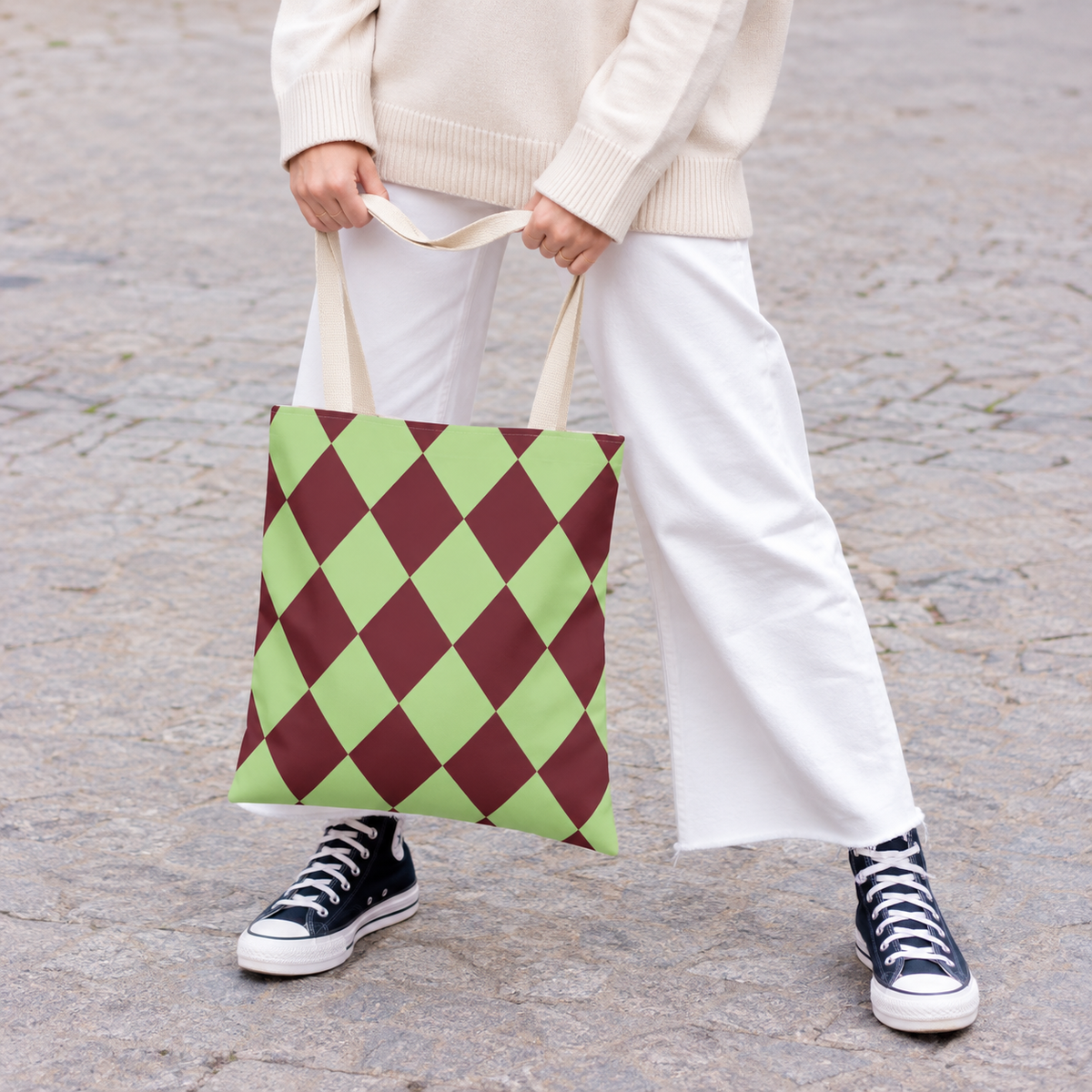 Woman in white trousers carrying the green burgundy diamond checkered tote bag