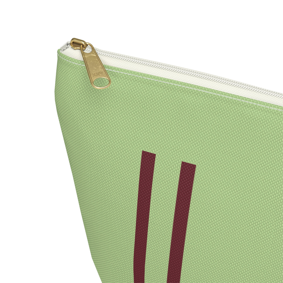 Close-up of the gold zipper pull and burgundy lines on the green personalized makeup bag