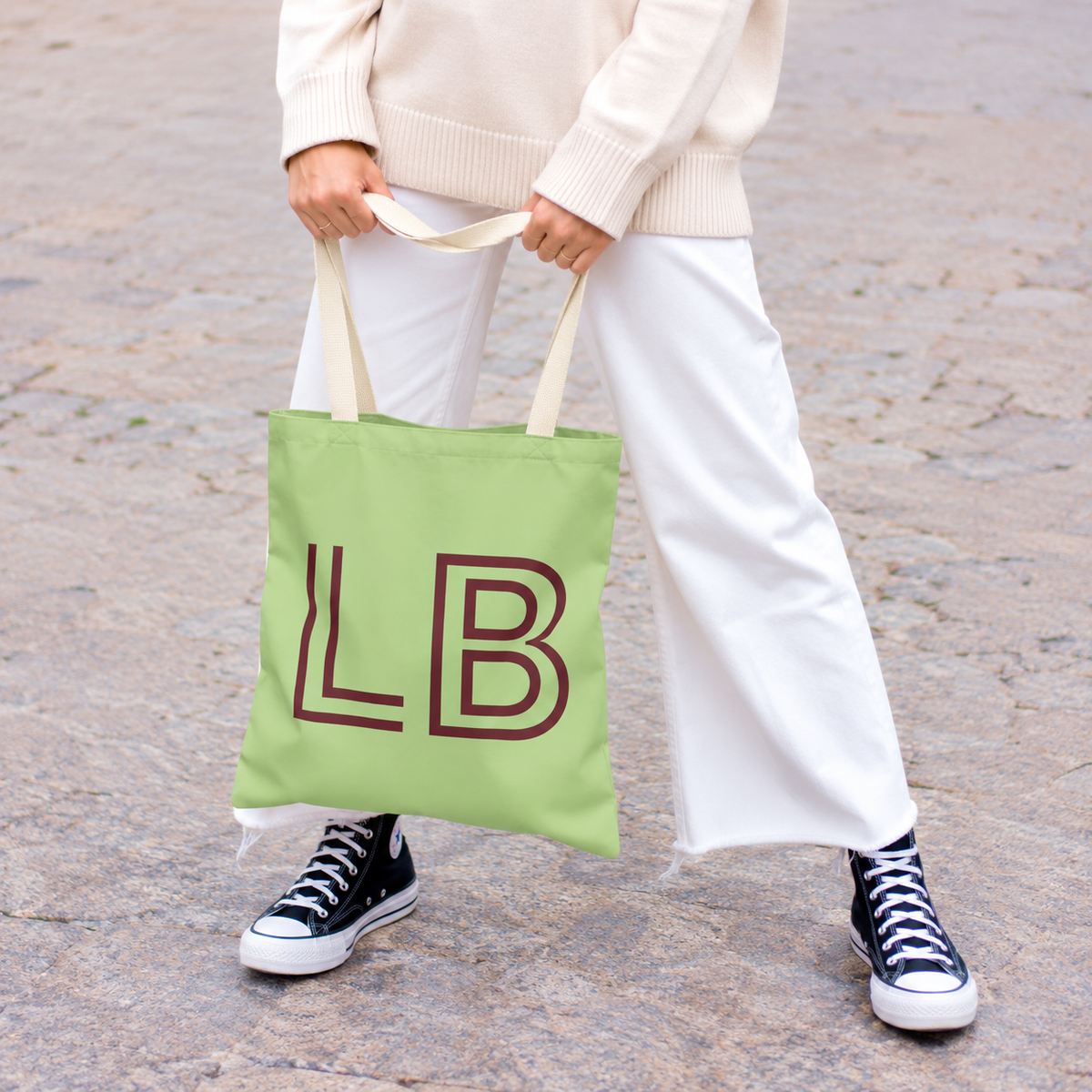 Model holding the green burgundy monogram personalized tote bag by its handles