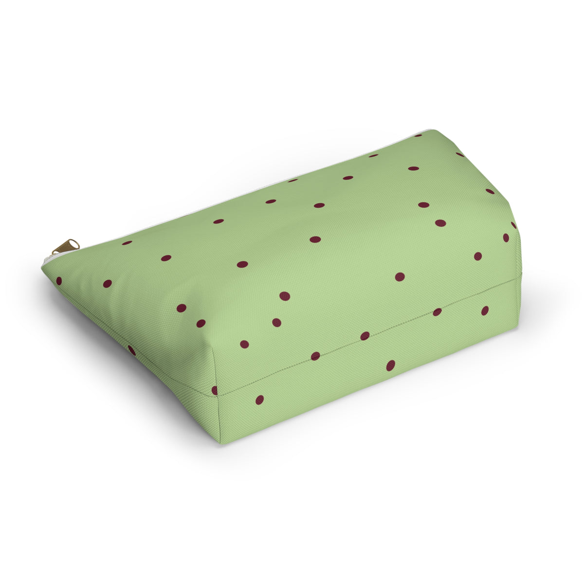 Side view of the green burgundy polka dot makeup bag lying down