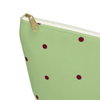 Close-up of the gold zipper pull and burgundy dots on the green makeup bag