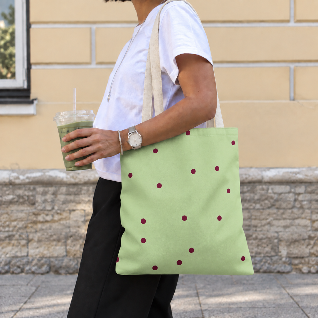 Woman walking with the green polka dot tote bag with burgundy dots on her shoulder