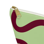 Close-up of the gold zipper pull on the green burgundy wavy line makeup bag