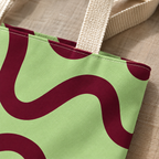 Close-up of the green burgundy wavy line print and handle on the tote bag