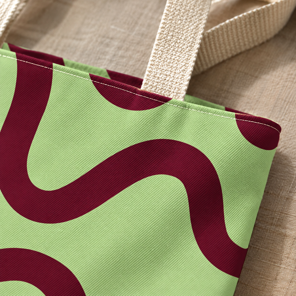 Close-up of the green burgundy wavy line print and handle on the tote bag