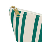 Close-up of the emerald green and cream stripes and gold zipper pull on the makeup bag