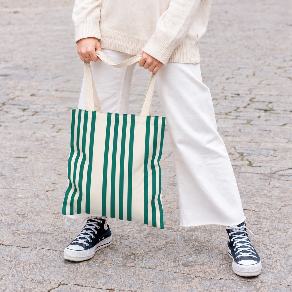 Model in white trousers carrying the Green Cream Striped tote bag