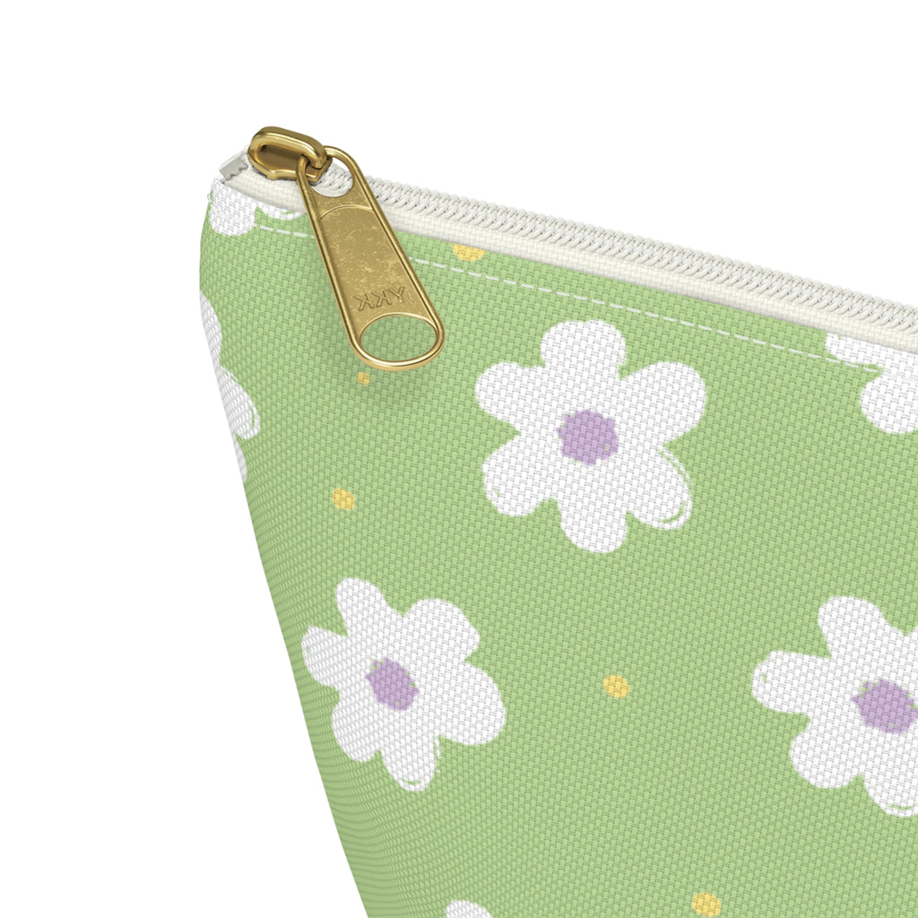 Close-up of the gold zipper pull and white daisy print on the green makeup bag