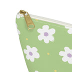 Close-up of the gold zipper pull and white daisy print on the green makeup bag