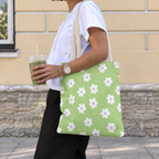 Side view of a model carrying the green daisy floral tote bag on her shoulder