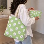 Woman carrying the green daisy floral tote bag with the matching makeup bag