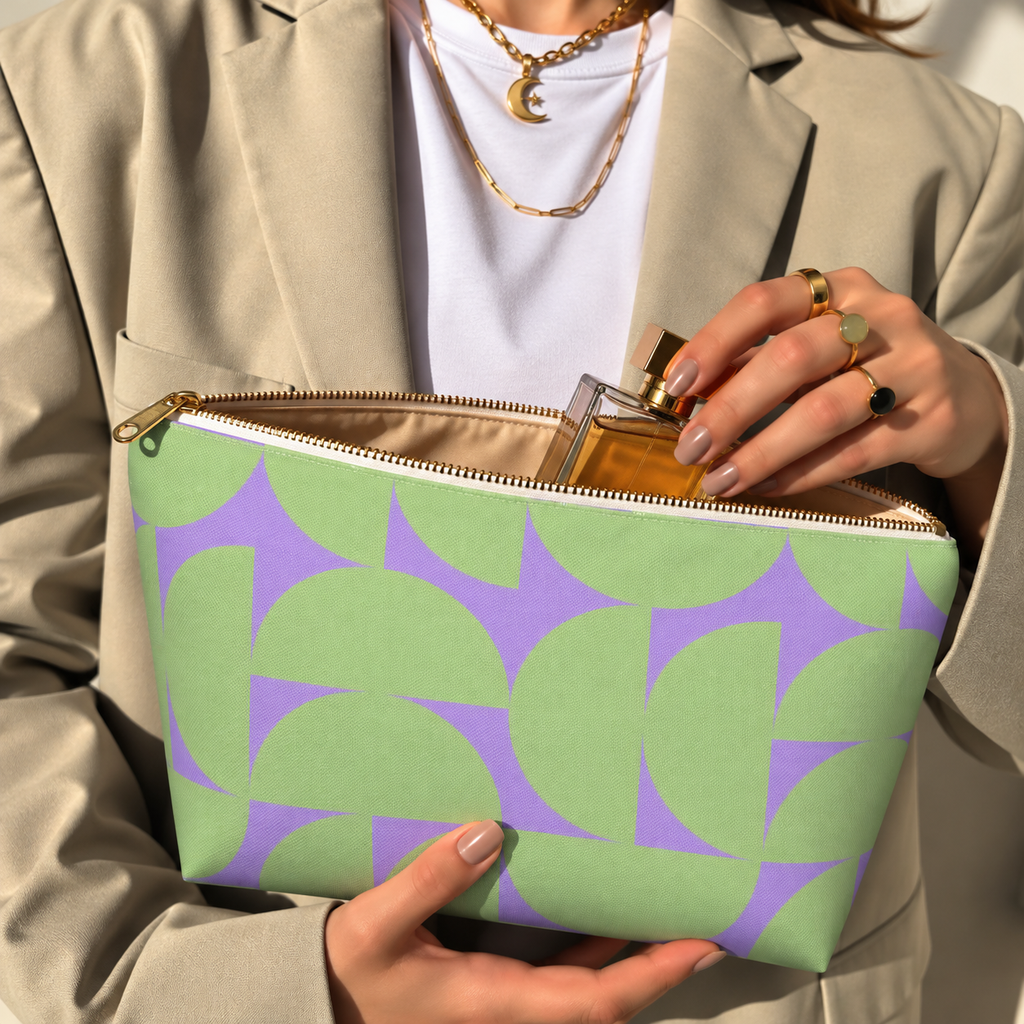Model in a beige blazer taking a product out of the open green lavender half circle makeup bag